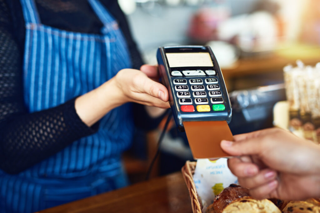 Man paying credit card at a grocery store or coffee shop